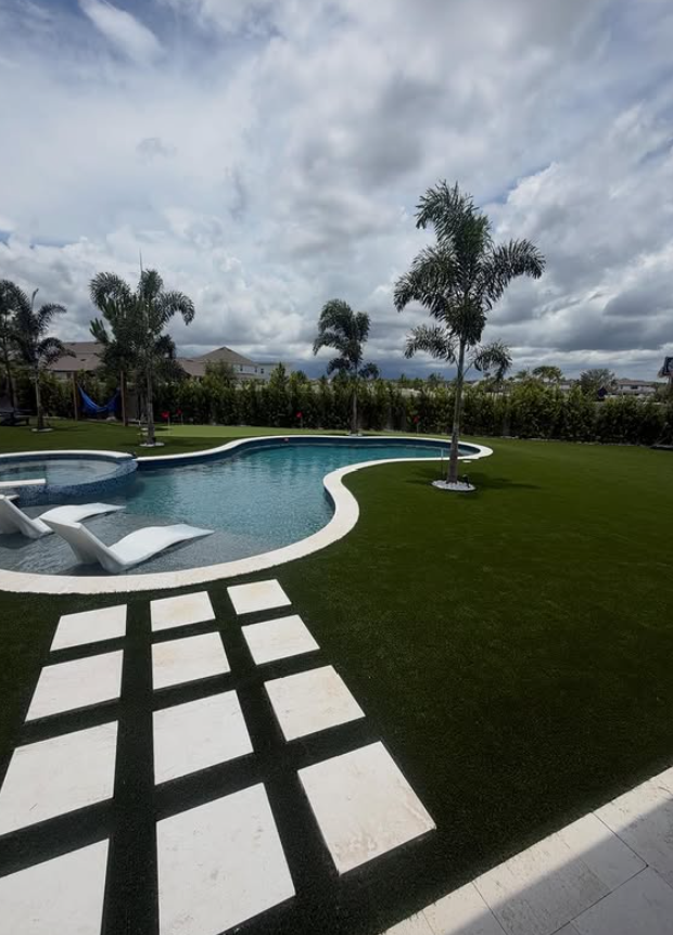 Backyard pool area after synthetic turf and putting green